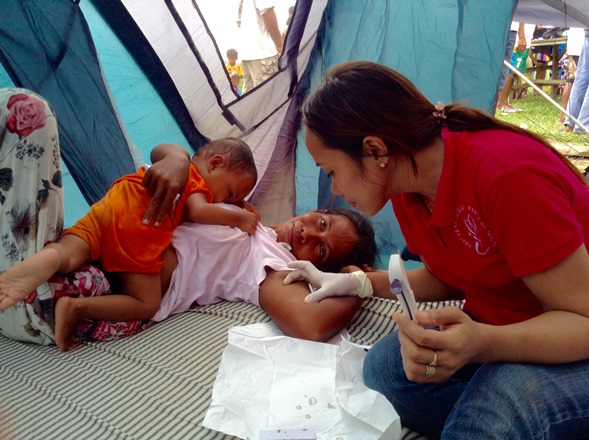 This mother of 10, a member of the Molbog tribe, receives a hormonal implant from midwife Mae Arzaga of Roots of Health, a Puerto Princesa-based women's health NGO. (Photo by Joie Cortina.) 
